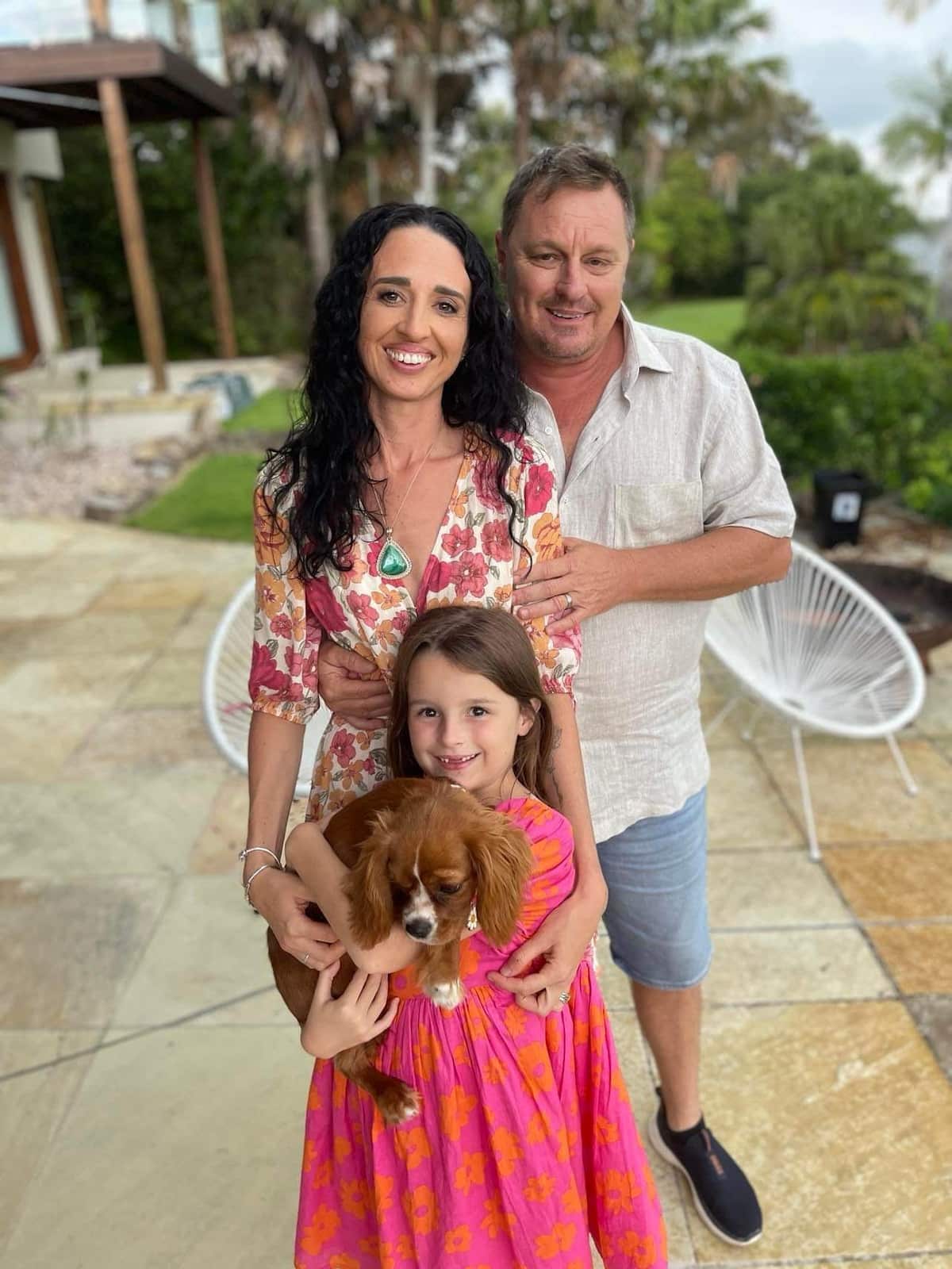 Raquel Billett and her family smiling together in backyard.